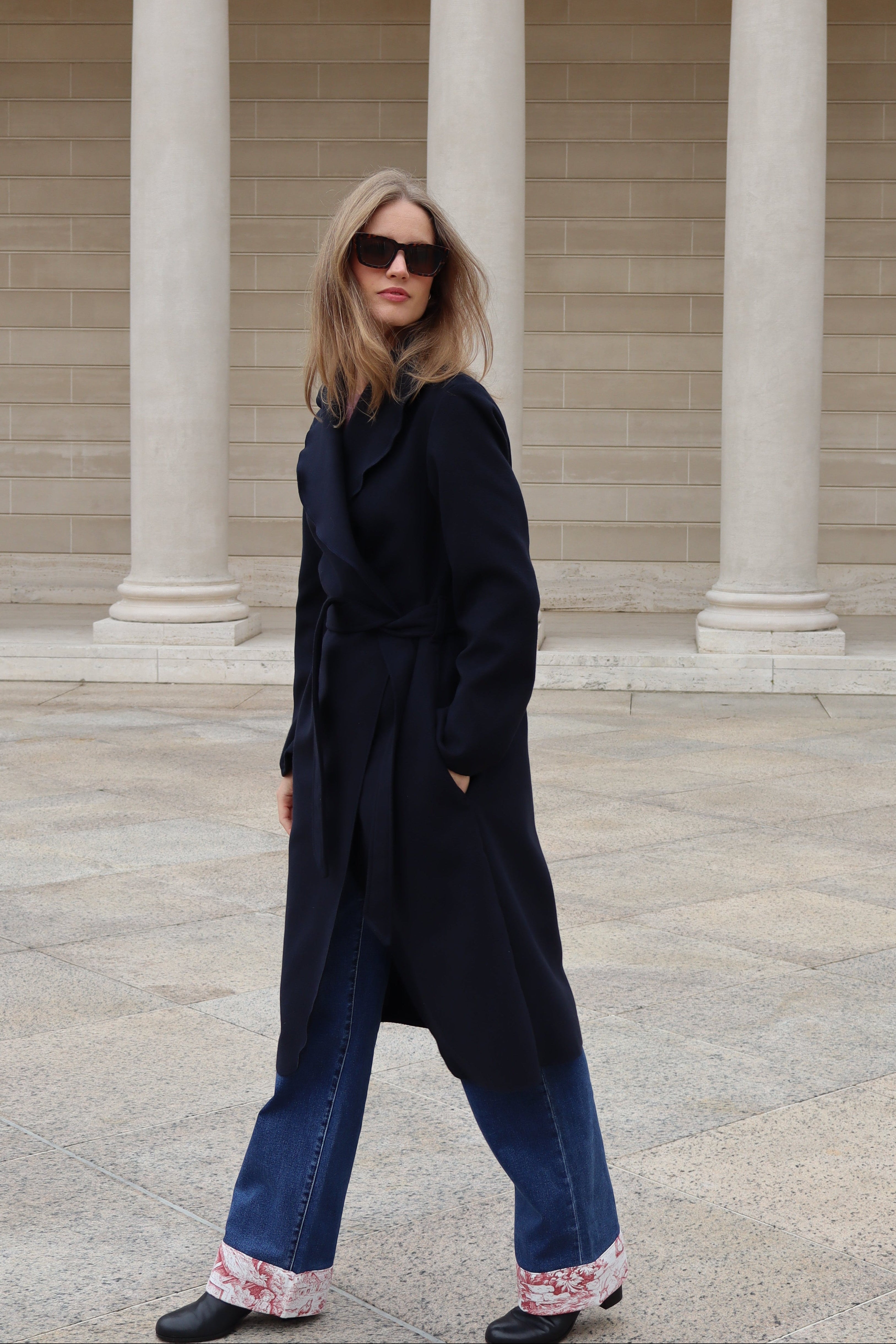Woman in navy coat and retro sunglasses
