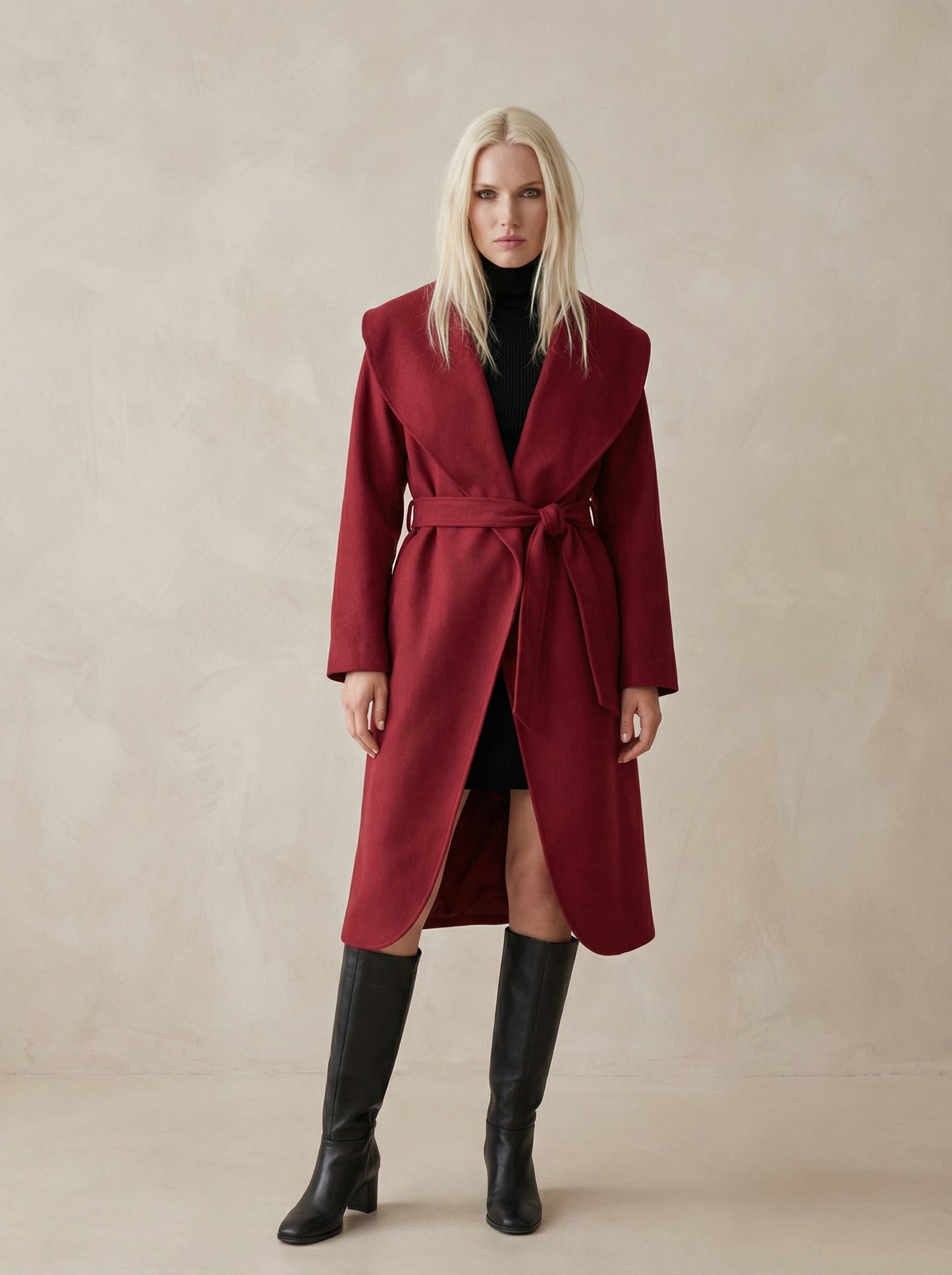 Woman wearing a red coat and black knee-high boots on a beige background