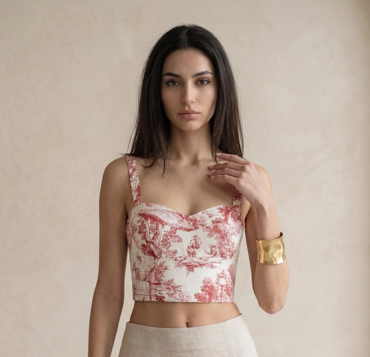 Woman wearing a red and white floral top with a beige background