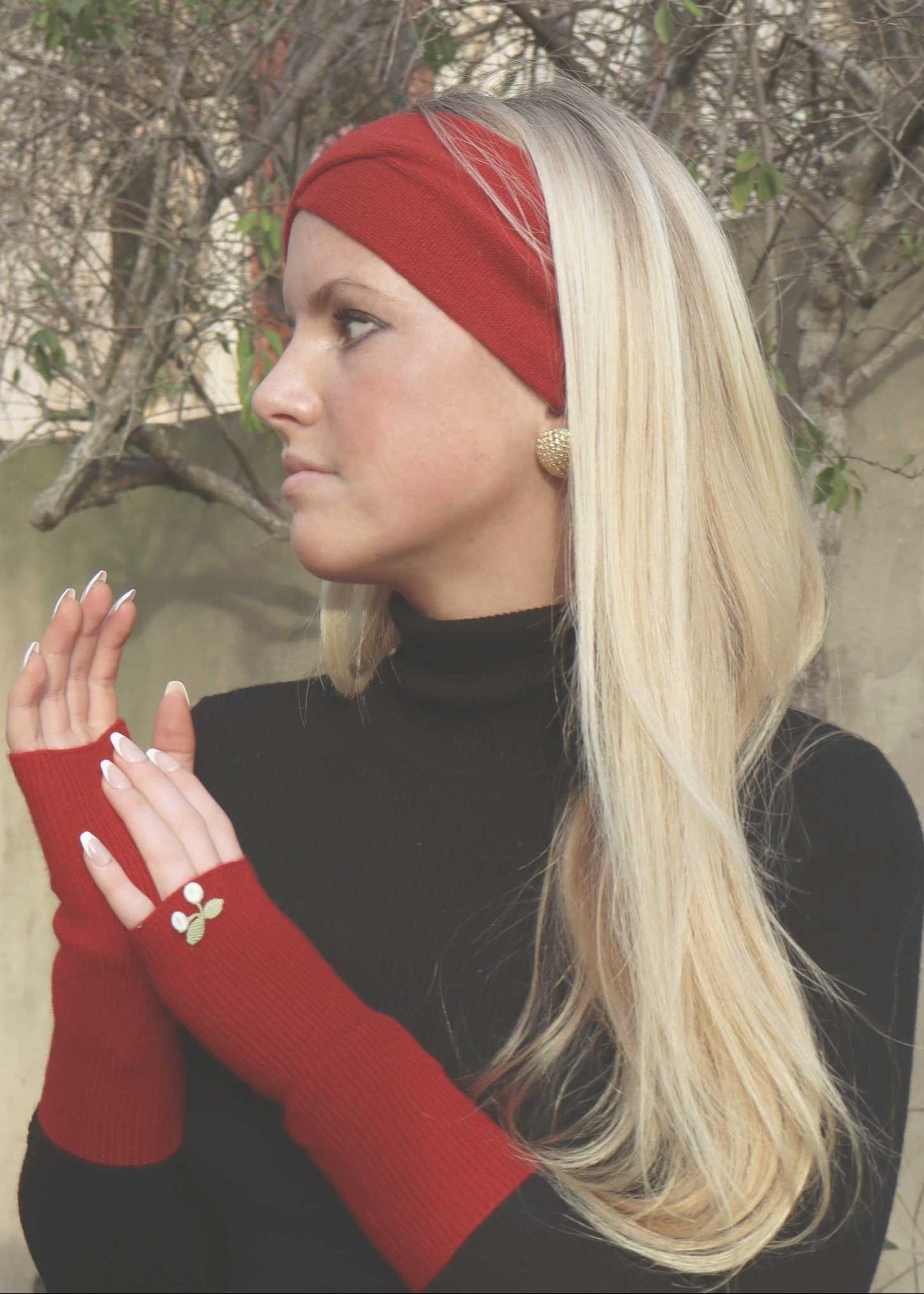 Woman wearing a red headband and arm warmers in an outdoor setting