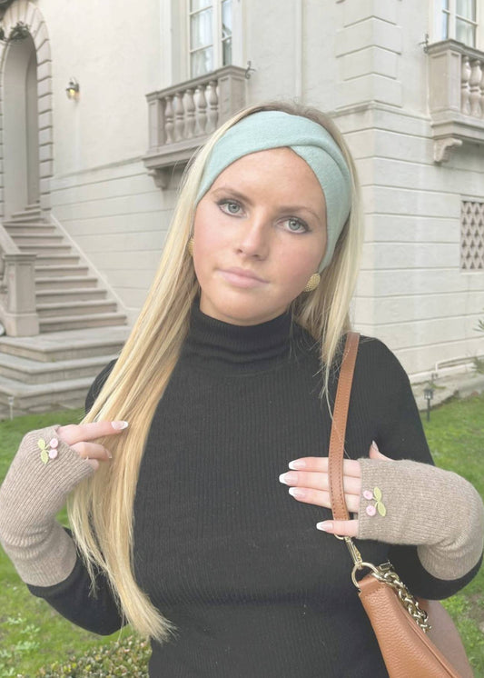 blonde woman in a green headband and black turtleneck