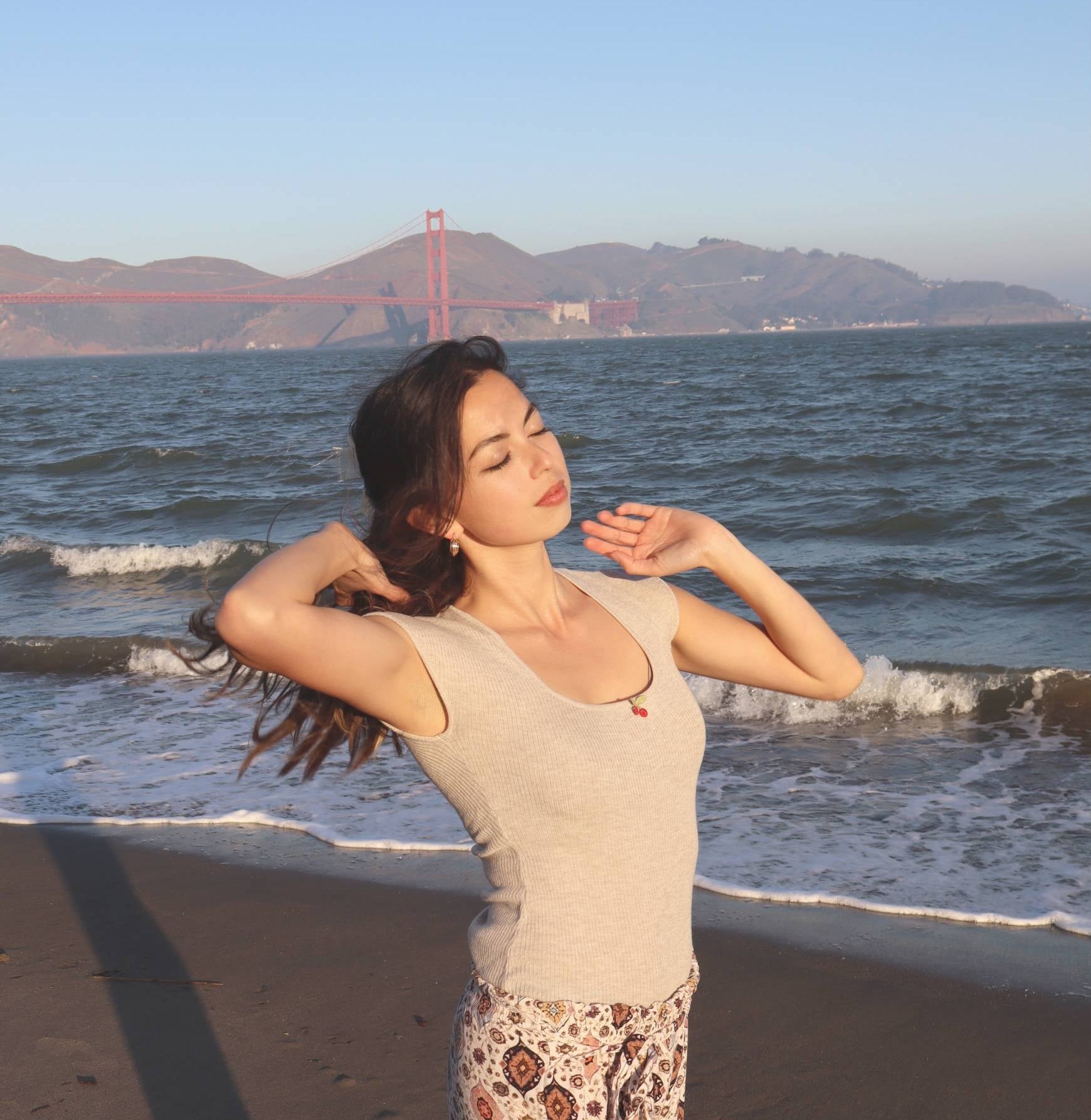 Woman on a beach with the Golden Gate Bridge in the background