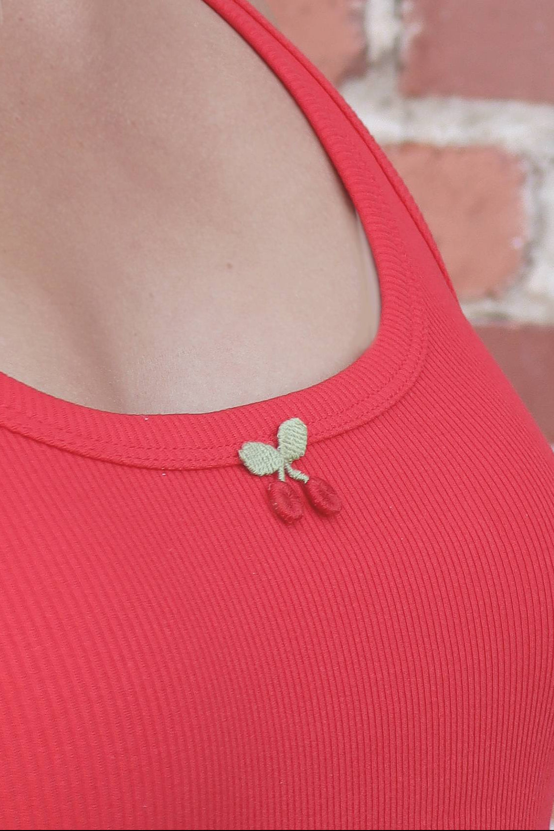 Close-up of a red garment with a decorative bow detail on a blurred background