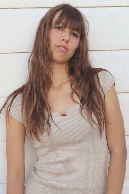 Woman with long hair standing against a light wooden panel background