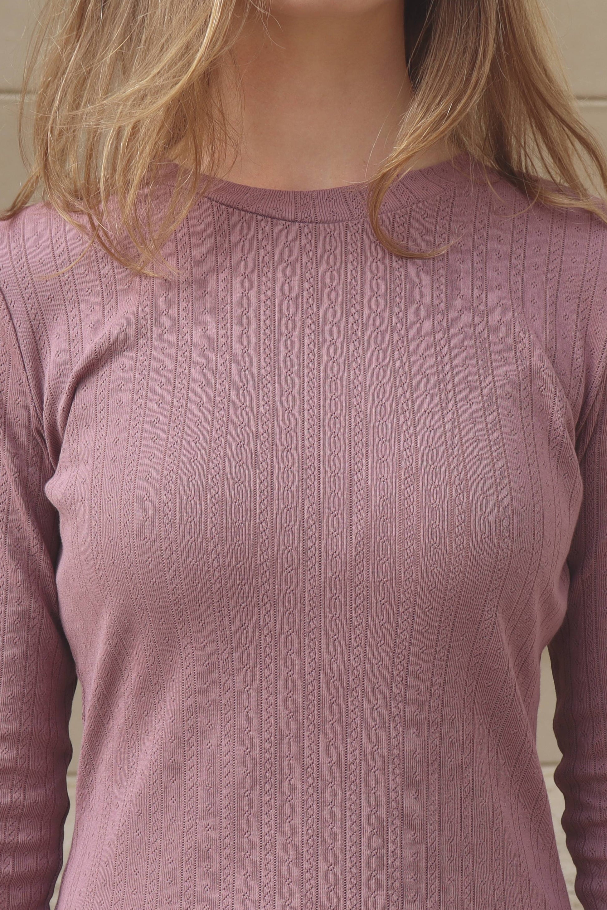 Blone woman in purple pointelle long sleeve top